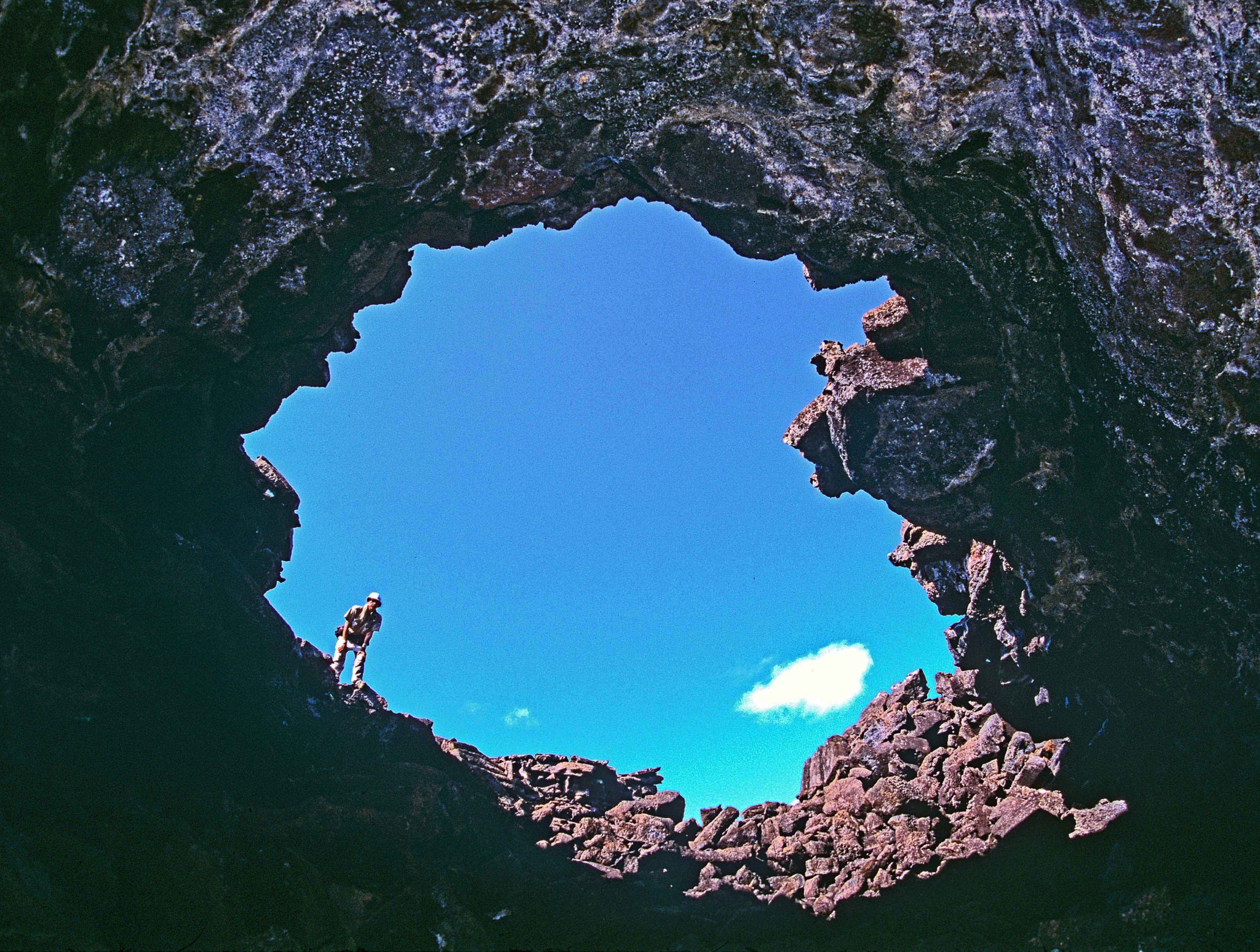 I am standing here on the lip of a giant pit crater in Darwin's "craterized district" on San Cristóbal.  "The entire surface of this part of the island," Darwin wrote, "seems to have been permeated, like a sieve, by the subterranean vapours: here and there the lava, whilst soft, has been blown into great bubbles; and in other parts, the tops of caverns similarly formed have fallen in, leaving circular pits with steep sides" (Journal of Researches, 1845, p. 374).