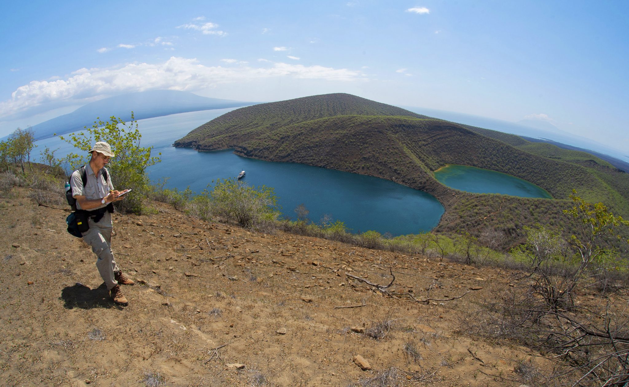 Another view of Tagus Cove and Lake Darwin from the ridge Darwin crossed to get to Beagle crater.  On the horizon to the left is Fernandina, the most active volcano in the archipelago.  Also visible on the horizon, to the right, is Volcan Ecuador, the northern-most of the six volcanoes that make up the island of Isabela.